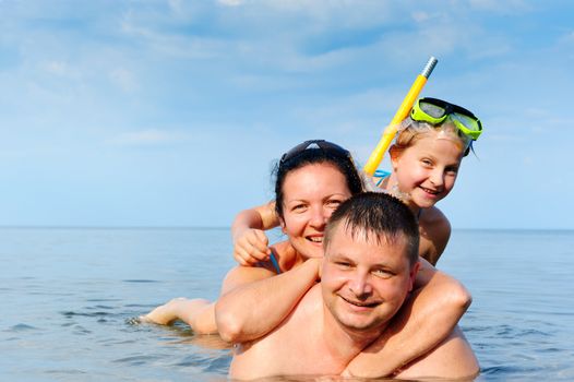 Happy family in the sea. Mum, the father and the daughter