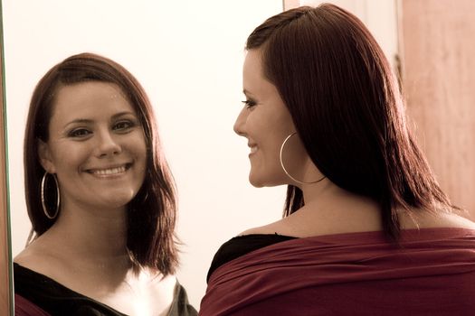 Young women looking at her reflection in a mirror with a big smile