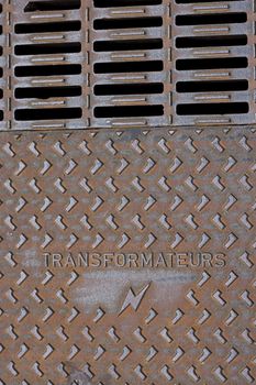 Rusted transformer street plate with french text