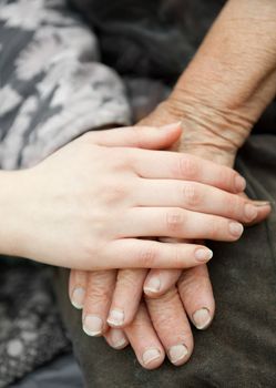 Old and young hands. Hands of the old woman - 84 years covered with young hands