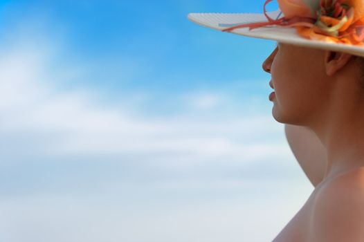 The girl in a hat against the blue sky