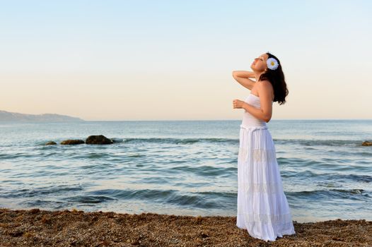 The woman in a white sundress on seacoast. A picturesque landscape