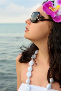 Portrait of the beautiful woman on seacoast. A profile, sun glasses