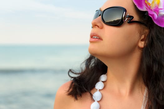 Portrait of the beautiful woman on seacoast. A profile, sun glasses