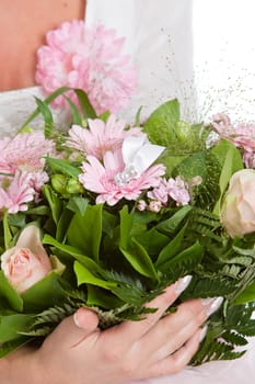 Woman holding a bouquet of flowers with a hidden engagement ring inside