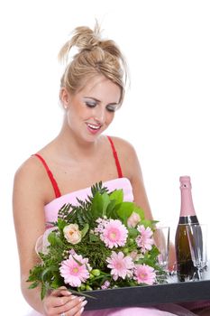 Beautiful blond girl getting a tray with flowers and champagne in bed for valentine