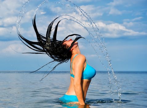 The woman with splashes from hair. Effect of movement