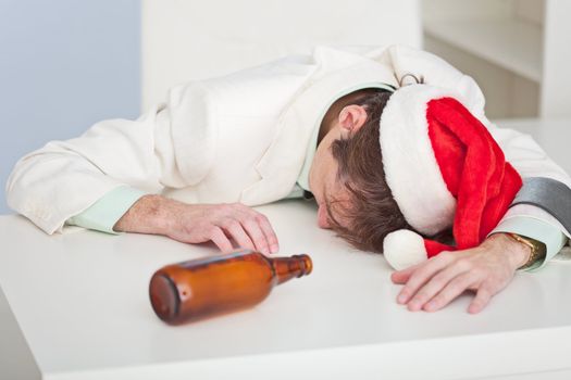 The drunk person in a Christmas cap lies on a white table