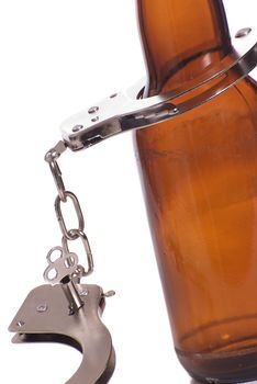 Concept image of drunk driving featuring a beer bottle and a pair of handcuffs, isolated against a white background