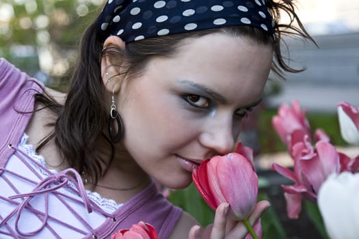 teenage girl smelling pick tulip