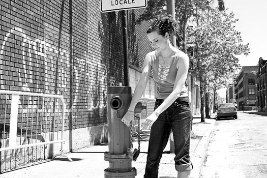 Teen girl playing with a fire hydrant