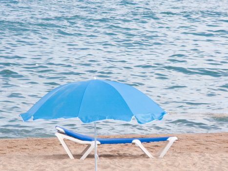 Blue umbrella an chair for relax in the beach
