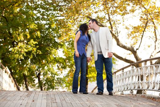 A couple kissing while walking in the park