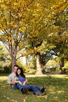 A happy couple relaxing in the park on grass