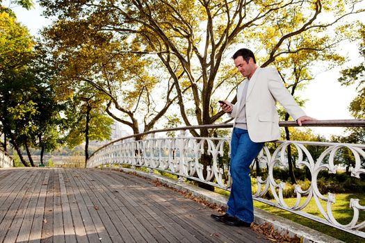 A man checking his cell phone in a park