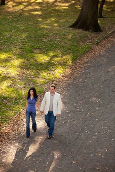 A man and woman walking in a park on a sunny day