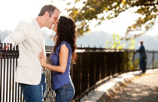 A happy couple in love kissing in the park