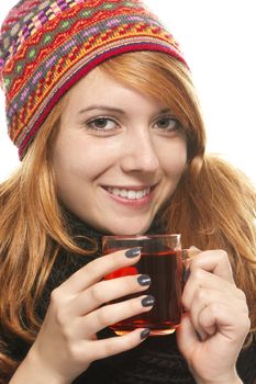 young smiling woman with winter cap warming-up with tea on white background