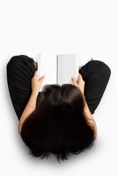 Girl reading a notebook on the floor over white background