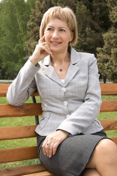 Mature middle-aged blond woman relaxing in a park