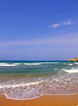 Clear blue Mediterranean waters on windy day, with beach and typical rocky coastline