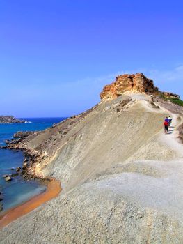 Adventure trio climbing up trek to the peak on top of clay slopes in Malta 