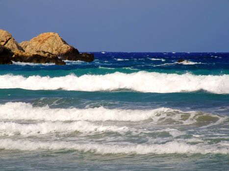 Clear blue Mediterranean waters on windy day, with rocky coastline