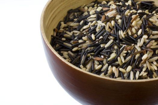 a wooden bowl of brown, wild, basmati rice mix against white background