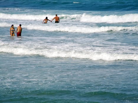 People having fun in the surf on a windy day in Malta