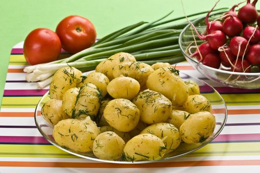 vegetarian food: cooked potatoes, tomato, spring onions and garden radish