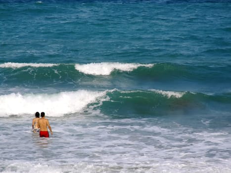 People having fun in the surf on a windy day in Malta