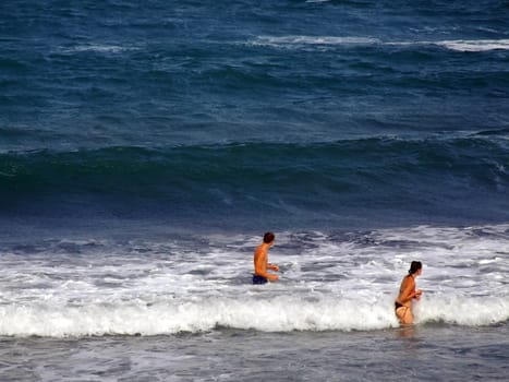 People having fun in the surf on a windy day in Malta