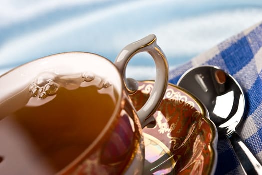 cup of tea with spoon over blue