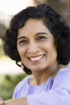 Portrait of a Smiling Indian Woman Sitting on a Bench in Park