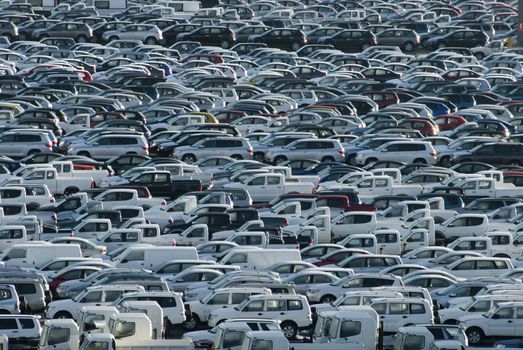 Rows of brand new cars and trucks parked and waiting for delivery