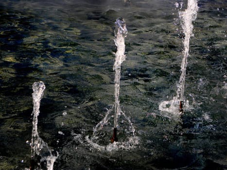 Part of the fountain in city, three short fountain columns.