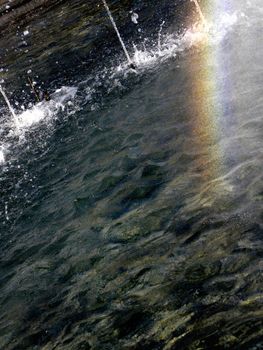 Part of the fountain with rainbow in background.