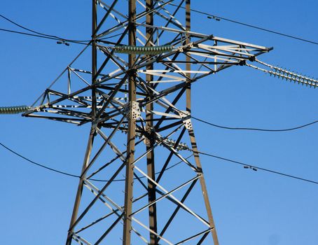 High voltage electricity closeup powerline on blue sky.