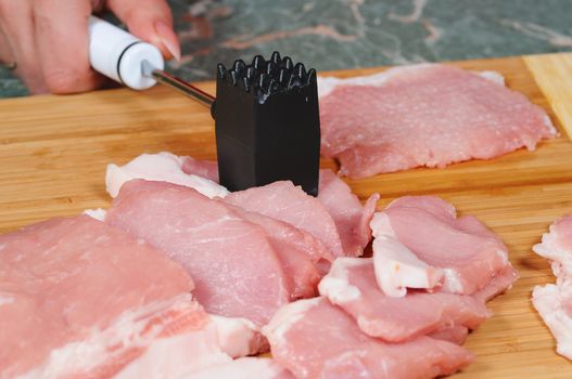 The cook prepares a chop from pork