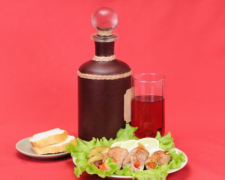 Still-life with meat and wine on a red background