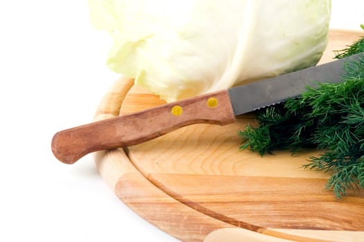 Cabbage and fennel on a wooden cutting board on a white background