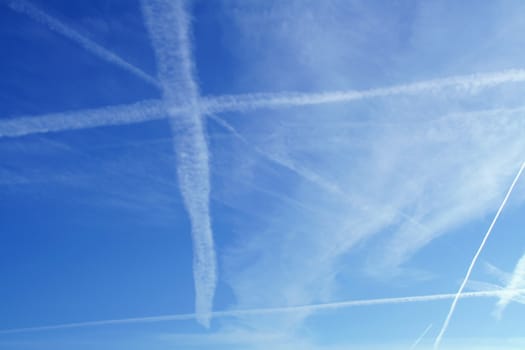 Morning blue sky with white contrails of jet aircraft