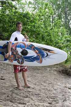 Male windsurfer in the wood saluting with a shaka gesture