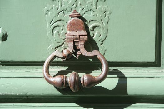 Houses on the streets of the capital of France - Paris. A fragment of the door with the door knockers.