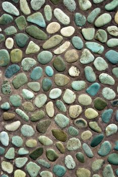 closeup of decorated garden pavement with blue stones in brown sand