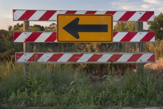 end of road barrier with arrow sign, weeds and vegatation of late summer in Colorado prairie