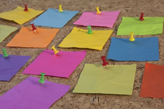 colorful blank notes pinned on cork bulletin board, low angle perspective