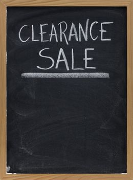 clearance sale text handwritten with white chalk on blackboard with copy space below