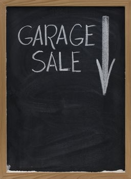 garage sale text handwritten with white chalk on vertical blackboard with arrow and copy space below