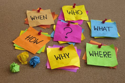 who, what, where, when, why, how questions - uncertrainty, brainstorming or decision making concept, colorful crumpled sticky notes on cork bulletin board